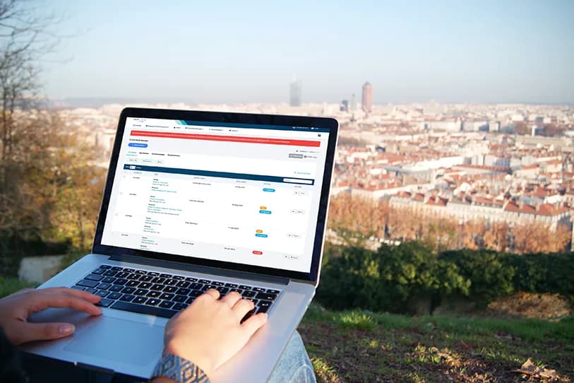 Person using a laptop displaying the Record TIME docket dashboard outdoors overlooking a city